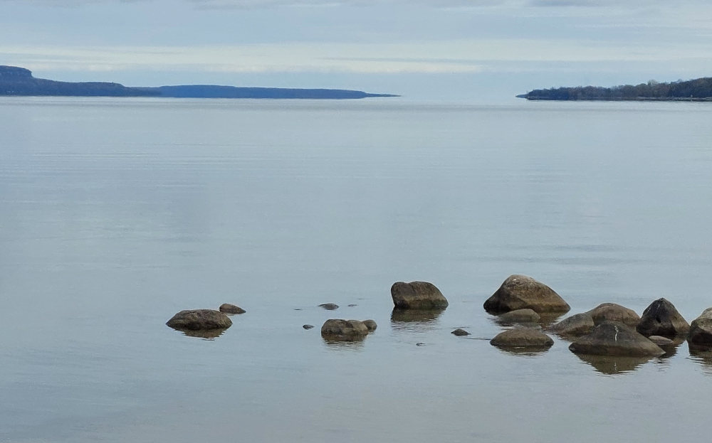 photo of colpoy's bay with rocks in the foreground